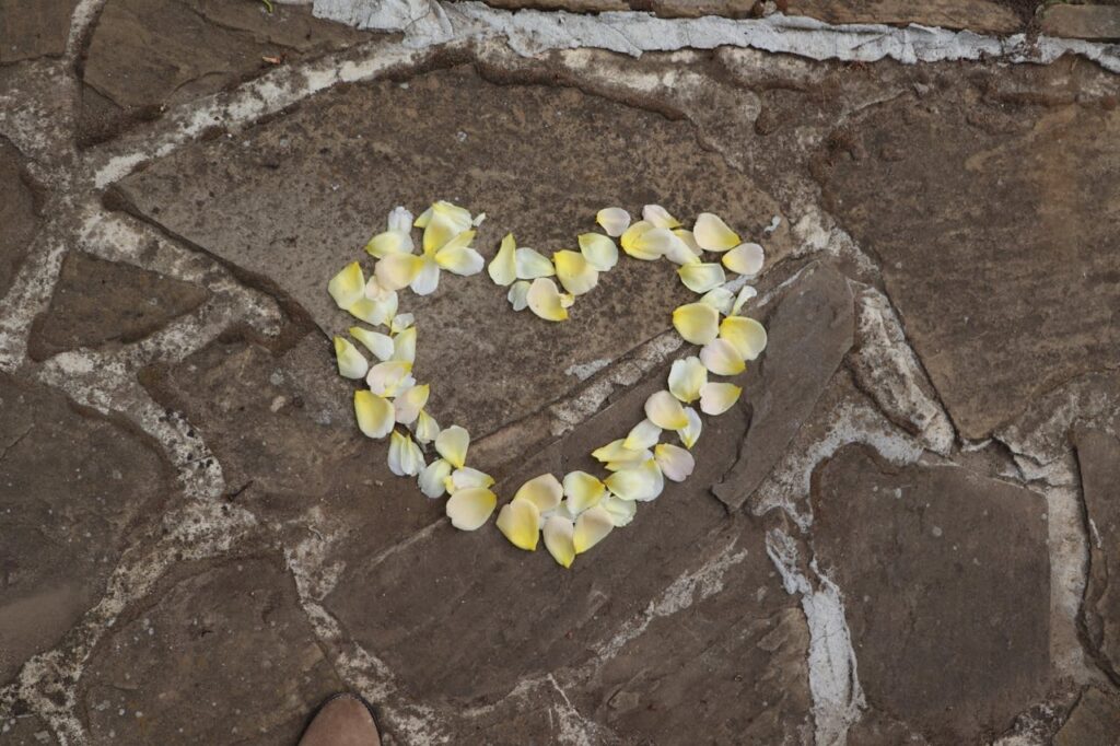 The Art of Drawing Readers In: Your attractive post title goes here A heart-shaped design of yellow petals arranged on a stone pavement.